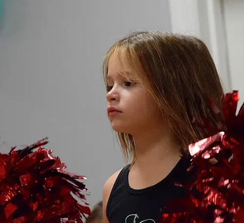 Niña bailando con un hermoso vestido en los festivales escolares.