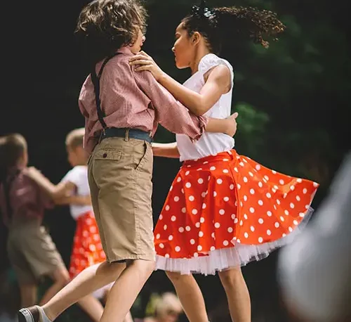 Niños bailando Danza Jazz con vestimenta adecuada para la actividad.