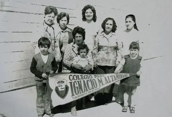 Los directivos de la escuela junto a sus familias y el banderín del colegio en la década de 1960.